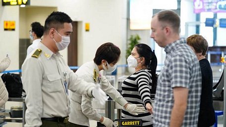  Nhân viên an ninh hàng không kiểm soát hành khách làm thủ tục chuyến bay. (Ảnh: CTV/Vietnam+)