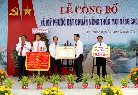 Ông Nguyễn Văn Liệt- Phó Chủ tịch UBND tỉnh trao cờ thi đua, bằng công nhận đạt chuẩn NTM nâng cao và khen thưởng công trình phúc lợi trị giá 500 triệu đồng cho xã Mỹ Phước.