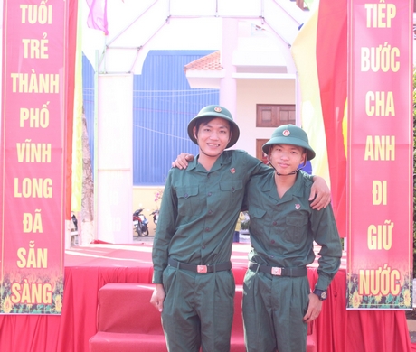 Tân binh Võ Đức Minh (trái) tự hào khi được khoác quân phục lên đường tòng quân.