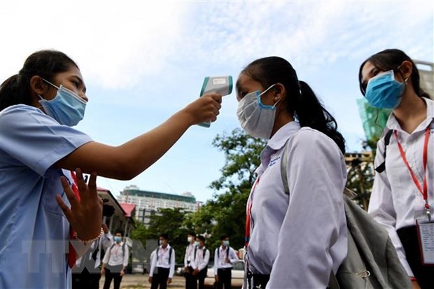 Đo thân nhiệt phòng lây nhiễm COVID-19 tại một trường học ở Phnom Penh, Campuchia. (Ảnh: AFP/TTXVN)