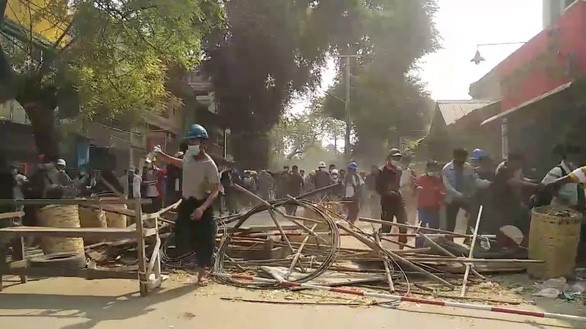 Người biểu tình Myanmar ở thành phố Mandalay rút lui khi bị cảnh sát dồn ép ngày 10/3. Theo mô tả của Reuters, những người này đã may mắn chạy thoát an toàn trước sự truy đuổi của lực lượng an ninh - Ảnh: REUTERS