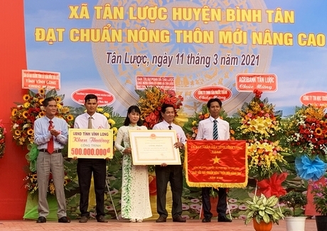 Ông Lê Quang Trung- Phó Chủ tịch Thường trực UBND tỉnh trao cờ thi đua, bằng công nhận đạt chuẩn NTM nâng cao và công trình phúc lợi xã hội trị giá 500 triệu đồng cho Đảng bộ và Nhân dân xã Tân Lược.