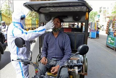 Nhân viên y tế lấy mẫu xét nghiệm COVID-19 cho người dân tại New Delhi, Ấn Độ, ngày 25/3/2021. Ảnh: THX/TTXVN