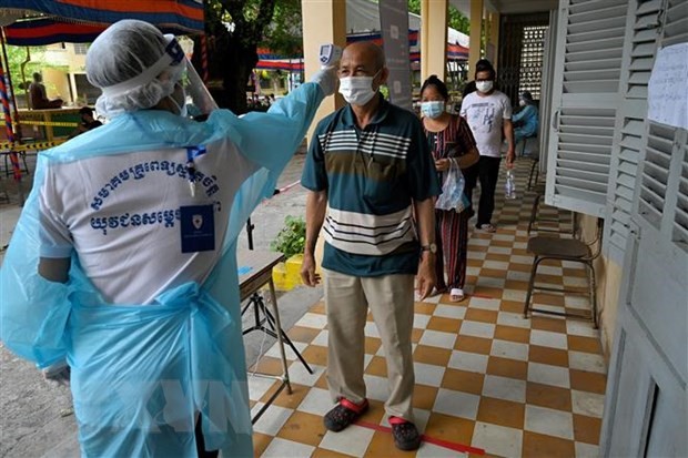 Kiểm tra thân nhiệt phòng lây nhiễm COVID-19 tại Phnom Penh, Campuchia, ngày 30/4/2021. (Ảnh: AFP/TTXVN)