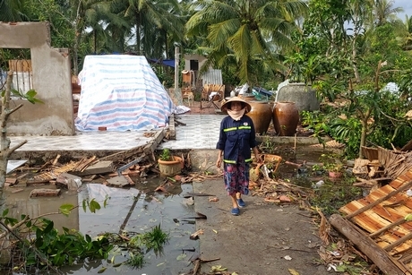 Chị Viếng đang kiểm tra đồ đạc còn sót lại nơi căn nhà đã sập.