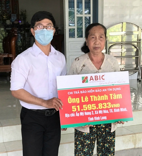 Cán bộ ABIC Cần Thơ tại Phòng Kinh doanh khu vực Vĩnh Long trao biểu trưng cho gia đình khách hàng.