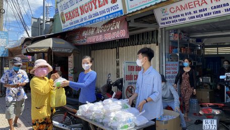 Người lao động tự do nhận phần ăn trưa miễn phí từ một nhóm thiện nguyện ở TP Vĩnh Long (ảnh chụp ngày 1/7/2021).