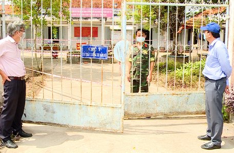 Ông Võ Trung Sơn- Phó Chủ tịch UBND huyện Long Hồ (bìa phải) đến thăm và động viên cán bộ, chiến sĩ đang làm nhiệm vụ tại khu cách ly.
