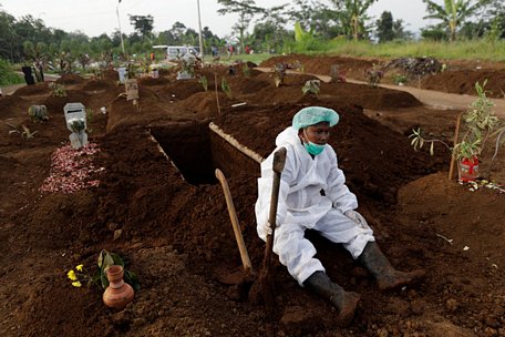 Một phu đào huyệt Indonesia ngồi nghỉ sau khi chôn cất một bệnh nhân COVID-19. Indonesia đang chứng kiến làn sóng bùng phát dịch vì biến thể Delta - Ảnh: REUTERS