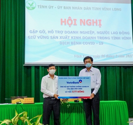 Giám đốc chi nhánh Ngân hàng Thương mại CP Công thương Vĩnh Long- Phạm Thành Lộc (phải) trao bảng ủng hộ 5 tỷ đồng.