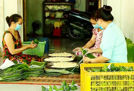 Bà Vân (trái) gói bánh ú hỗ trợ người dân khu vực ảnh hưởng dịch bệnh.