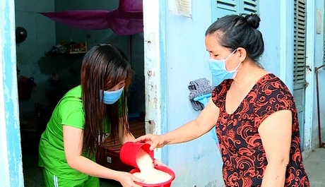 Bà Ngoi (phải) đem gạo hỗ trợ cho công nhân.