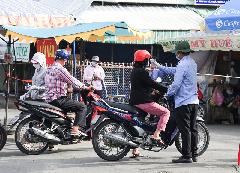 Những người ra vào chợ đều được đo thân nhiệt.