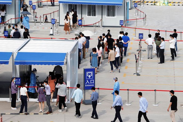 Nhân viên sân bay quốc tế Phố Đông (Pudong) Thượng Hải xếp hàng xét nghiệm COVID-19 tại thành phố Thượng Hải, Trung Quốc ngày 20/8 - Ảnh: REUTERS