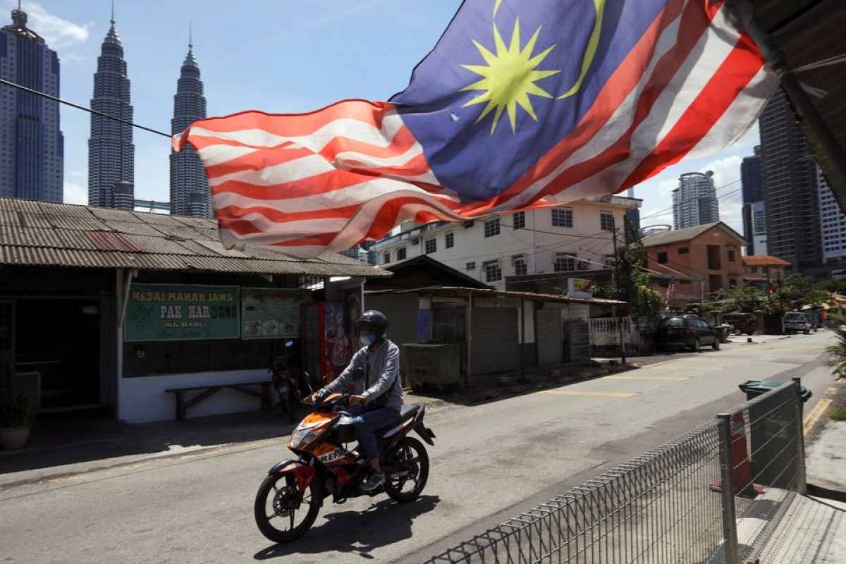 Một người đàn ông đeo khẩu trang lái xe máy trên đường phố Kuala Lumpur, Malaysia ngày 2/2/2021. Ảnh: Reuters