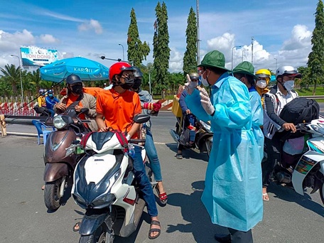 Đoàn viên Trường ĐH Sư phạm kỹ thuật Vĩnh Long phân luồng và hướng dẫn người dân từ TP Hồ Chí Minh về.