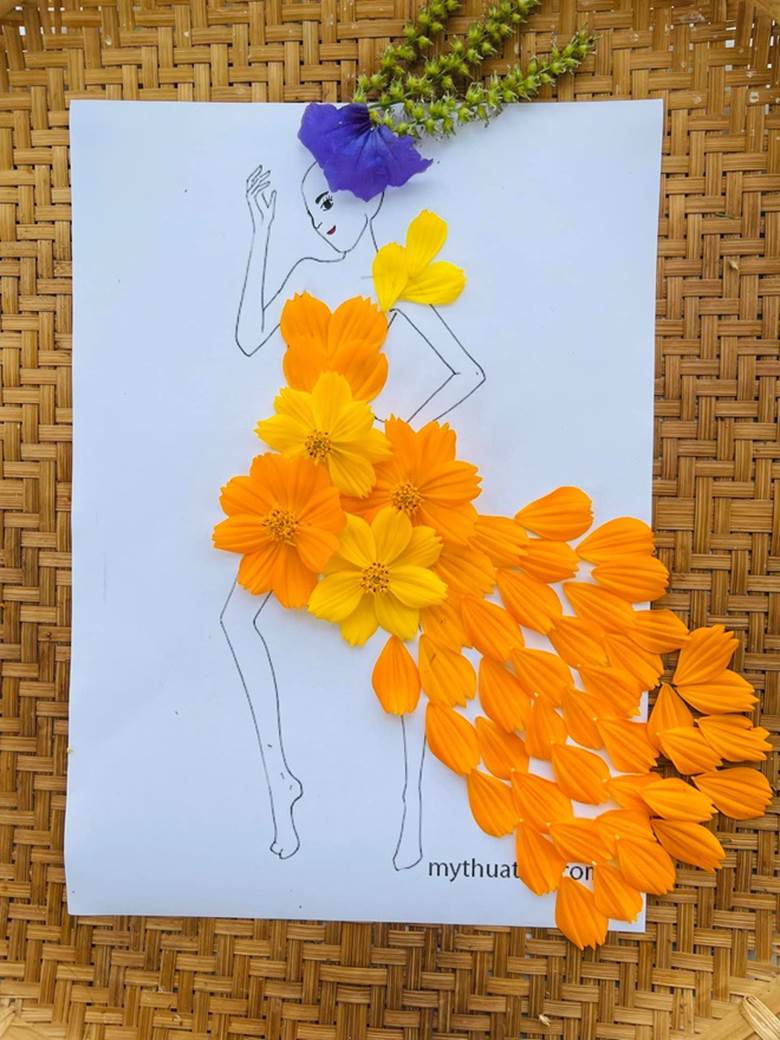 Bộ váy công chúa làm từ vận dụng sự mềm mỏng của cánh hoa tạo nên sự uyển chuyển và sống động. Không chỉ thu hút với màu cam rực rỡ, chị Loan còn dùng cánh hoa màu tím tô điểm thêm cho mái tóc, tăng phần hấp dẫn hơn.