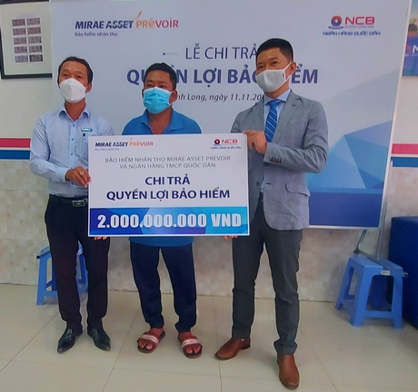 Đại diện NCB Vĩnh Long và Công ty TNHH Bảo hiểm Nhân thọ Mirae Asset Prévoir trao tượng trưng 2 tỷ đồng quyền lợi bảo hiểm cho gia đình khách hàng S.
