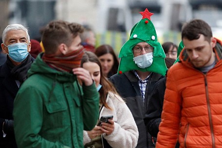 Người đàn ông đội mũ cây thông Noel và đeo khẩu trang phòng dịch ở thủ đô London, “tâm dịch” của nước Anh, hôm 19/12 - Ảnh: Reuters