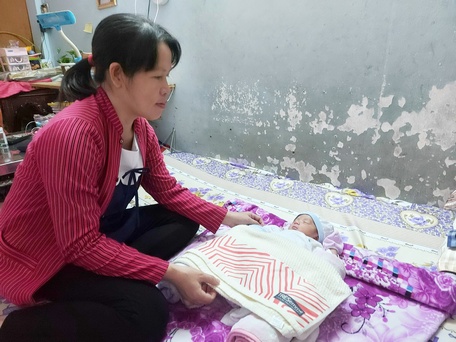 Chị Trương Ngọc Sự ngắm nhìn con gái nhỏ vừa tròn tháng đang say giấc.