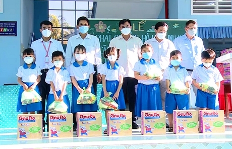 Thầy Trí (bìa trái) tặng quà cho học sinh hiếu học.