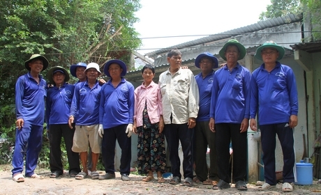 Anh Lê Minh Trung (thứ 4 từ trái sang) trong nhóm anh em cất nhà cho bà Nguyễn Thị Bảy, ở xã Long An (Long Hồ).