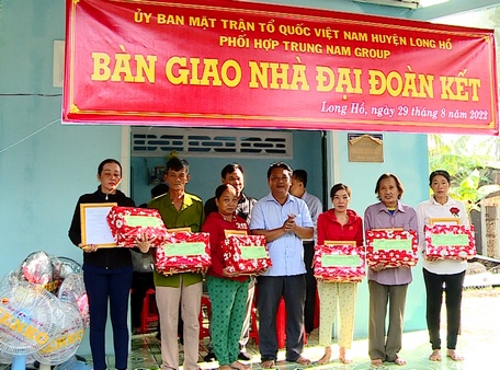 Đồng chí Hồ Văn Minh- Bí thư Huyện ủy Long Hồ tặng quà cho các hộ gia đình được bàn giao nhà đại đoàn kết.