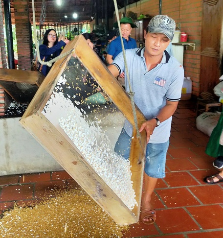 Các điểm du lịch Vĩnh Long ngày chú trọng đa dạng loại hình tham quan, vui chơi. Trong ảnh: Du khách xem cách làm cốm ở cù lao An Bình (Long Hồ).