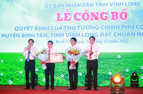 Bí thư Tỉnh ủy- Bùi Văn Nghiêm và Chủ tịch UBND tỉnh- Lữ Quang Ngời trao bằng công nhận của Thủ tưởng Chính phủ công nhận huyện Bình Tân đạt chuẩn huyện NTM và tặng hoa chúc mừng huyện Bình Tân.