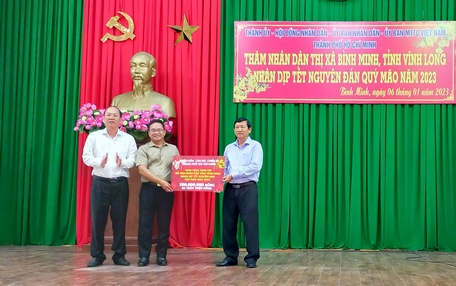 Ông Nguyễn Hồ Hải - Phó Bí thư Thành ủy TP Hồ Chí Minh và ông Phạm Minh Tuấn - Phó Chủ tịch Ủy ban MTTQ Việt Nam TP Hồ Chí Minh trao bảng tượng trưng số tiền hỗ trợ đến ông Hồ Văn Huân - Chủ tịch Ủy ban MTTQ Việt Nam tỉnh Vĩnh Long.