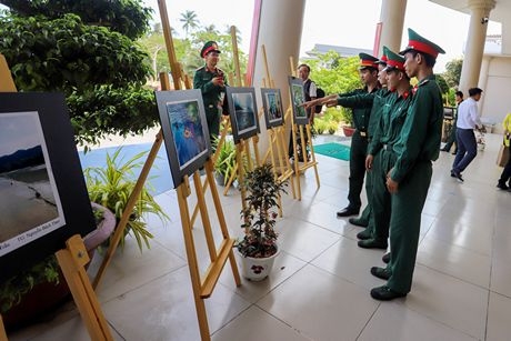 Đông đảo du khách và bộ đội đến xem triển lãm tranh, ảnh nghệ thuật.