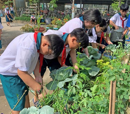 Thiếu nhi chăm sóc vườn rau liên đội.