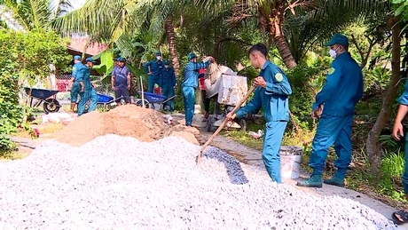 Lực lượng dân quân và người dân địa phương chung tay sửa chữa, giặm vá tuyến đường đan tại các ấp Trà Mòn- Mỹ Định (xã Tân Mỹ).