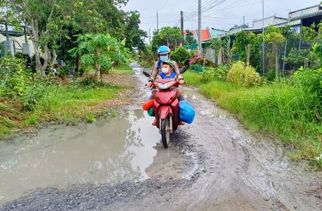  Việc đi lại của phụ huynh, học sinh và người dân rất khó khăn do đường thường xuyên bị lầy lội và ngập sau mưa.