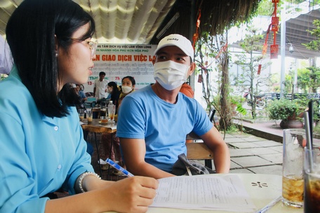 Người lao động (bên phải) dự phiên giao dịch việc làm được tư vấn hỗ trợ học nghề, giới thiệu việc làm, giải quyết chính sách bảo hiểm thất nghiệp.